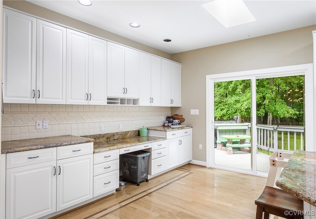 10598 Lambeth Rd, Glen Allen, VA 23060 - kitchen featuring backsplash, light wood-type flooring, a skylight, stone countertops, and white cabinets