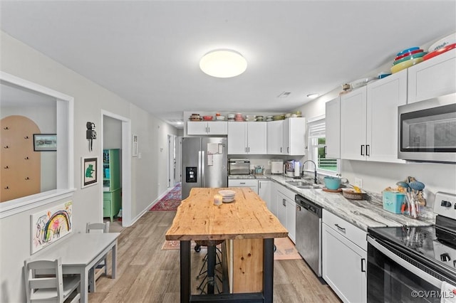 520 Monte Verde Rd, Center Cross, VA 22437 - kitchen with stainless steel appliances, white cabinets, light wood-type flooring, and light stone countertops