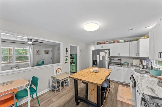 520 Monte Verde Rd, Center Cross, VA 22437 - kitchen featuring stainless steel appliances, light wood finished floors, white cabinets, light stone counters, and a ceiling fan