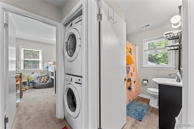 520 Monte Verde Rd, Center Cross, VA 22437 - laundry area with stacked washing machine and dryer, healthy amount of natural light, and light wood finished floors