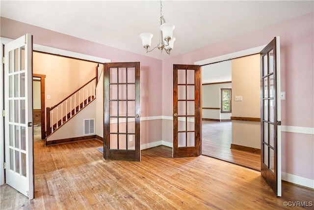 3180 Judes Ferry Rd, Powhatan, VA 23139 - unfurnished room with french doors, wood-type flooring, a chandelier, and stairs
