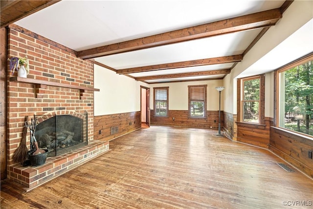 3180 Judes Ferry Rd, Powhatan, VA 23139 - unfurnished living room featuring a wainscoted wall, wood finished floors, wooden walls, healthy amount of natural light, and beamed ceiling