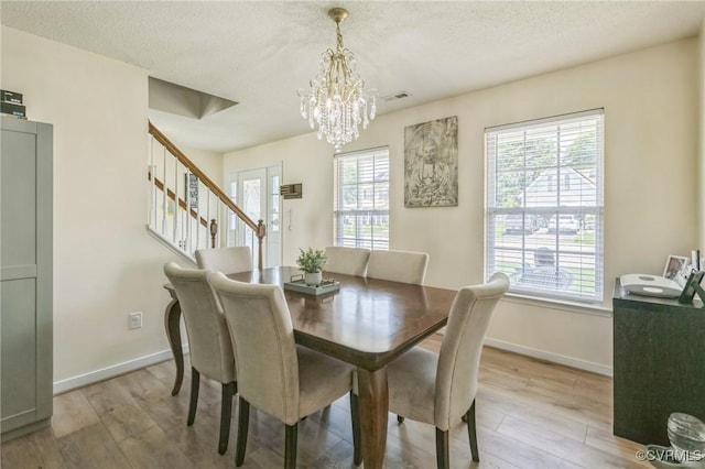 3706 Paul Karnes Dr, Hopewell, VA 23860 - dining room featuring a chandelier, light wood-style flooring, stairs, and a textured ceiling