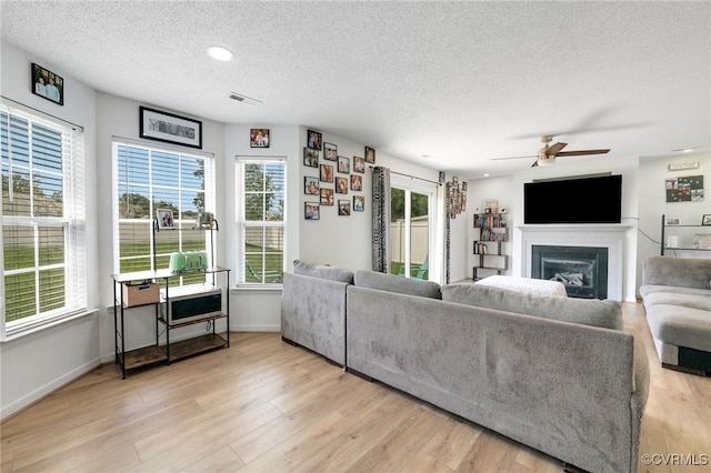 3706 Paul Karnes Dr, Hopewell, VA 23860 - living room with a textured ceiling, a ceiling fan, a glass covered fireplace, light wood finished floors, and recessed lighting