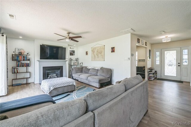 3706 Paul Karnes Dr, Hopewell, VA 23860 - living area with a textured ceiling, wood finished floors, ceiling fan, and a glass covered fireplace