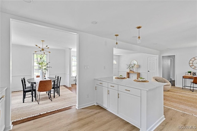 1908 Windsordale Dr, Henrico, VA 23229 - kitchen featuring light wood-type flooring, white cabinets, hanging light fixtures, light stone countertops, and open floor plan