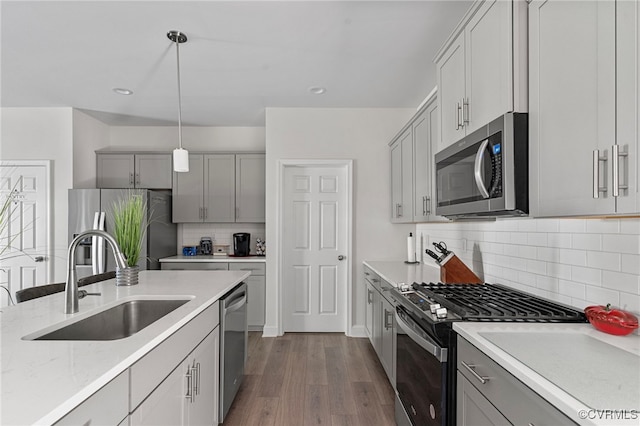 7001 Leire Ln, Chesterfield, VA 23832 - kitchen with appliances with stainless steel finishes, dark wood finished floors, tasteful backsplash, pendant lighting, and gray cabinets