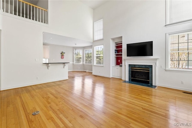 5908 Dominion Fairways Ct, Glen Allen, VA 23059 - unfurnished living room featuring light wood-style floors, a high ceiling, a fireplace, and built in features