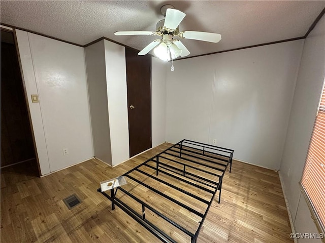 2305 Swift Bluff Dr, South Chesterfield, VA 23834 - bedroom with wood finished floors, a textured ceiling, crown molding, a ceiling fan, and a closet