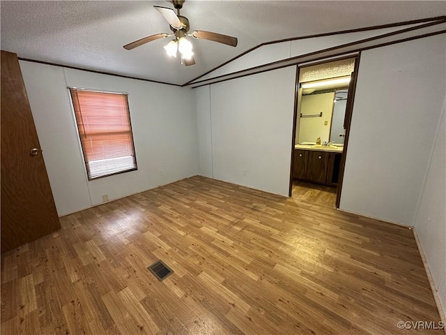 2305 Swift Bluff Dr, South Chesterfield, VA 23834 - unfurnished bedroom featuring light wood-style floors, lofted ceiling, connected bathroom, ceiling fan, and a textured ceiling