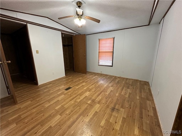 2305 Swift Bluff Dr, South Chesterfield, VA 23834 - unfurnished bedroom featuring light wood finished floors, vaulted ceiling, a closet, ceiling fan, and a textured ceiling