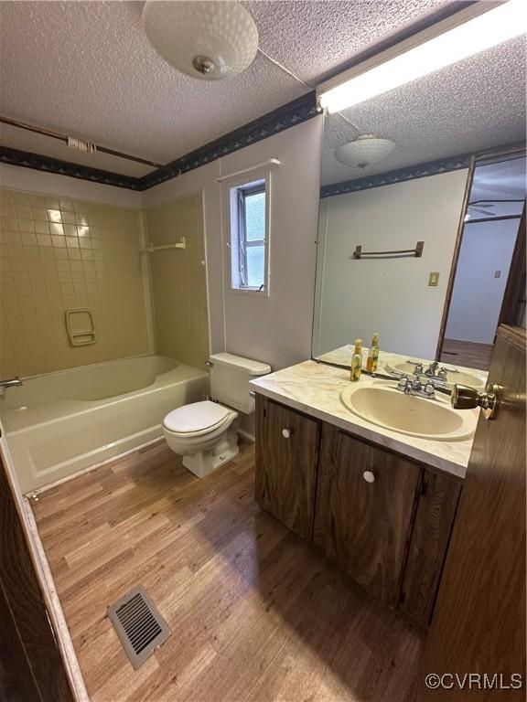 2305 Swift Bluff Dr, South Chesterfield, VA 23834 - bathroom featuring wood finished floors, vanity,  shower combination, and a textured ceiling