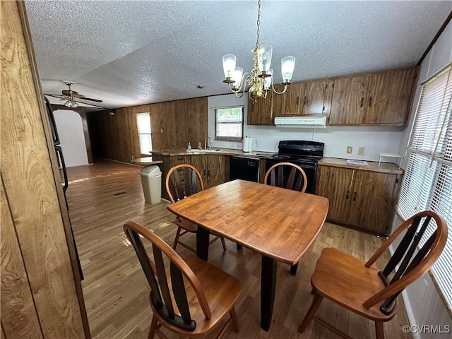 2305 Swift Bluff Dr, South Chesterfield, VA 23834 - dining room featuring a textured ceiling, a chandelier, ceiling fan, light wood-style floors, and wood walls