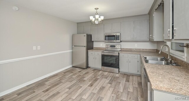 2131 Highland Dr, Powhatan, VA 23139 - kitchen with stainless steel appliances, gray cabinets, a chandelier, light wood-style flooring, and a wainscoted wall