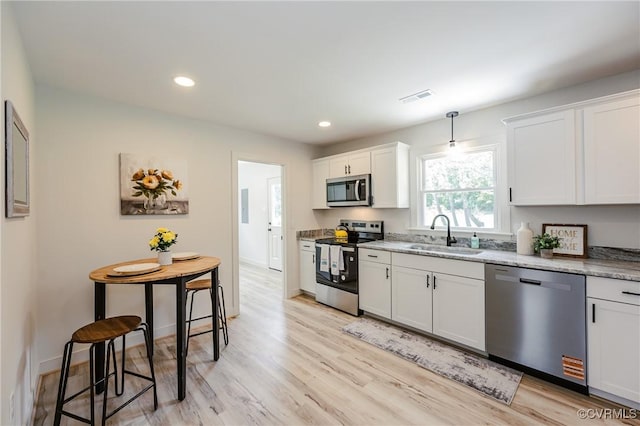 4300 N Courthouse Rd, Providence Forge, VA 23140 - kitchen with appliances with stainless steel finishes, light wood finished floors, light stone countertops, white cabinetry, and recessed lighting