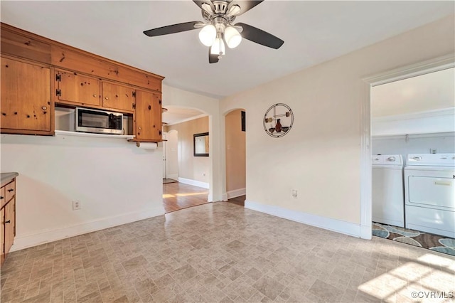 4305 Lakeview Rd, South Chesterfield, VA 23803 - kitchen with stainless steel microwave, washing machine and dryer, arched walkways, ceiling fan, and brown cabinets