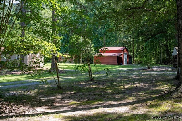 844 Rocky Point Lndg, Cobbs Creek, VA 23035 - view of green lawn with a garage, a shed, and a wooded view