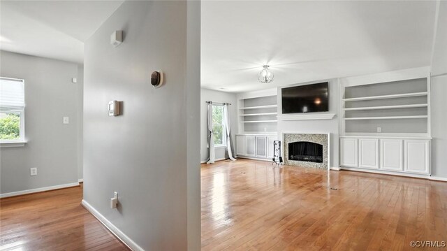 566 Abbey Village Cir, Midlothian, VA 23114 - unfurnished living room with wood finished floors, built in shelves, and a fireplace