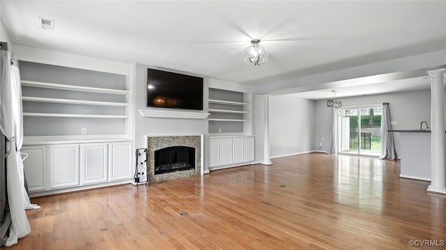 566 Abbey Village Cir, Midlothian, VA 23114 - unfurnished living room with ornate columns, light wood-style floors, a fireplace, and built in shelves