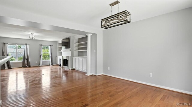 566 Abbey Village Cir, Midlothian, VA 23114 - unfurnished living room featuring wood finished floors, a fireplace, and decorative columns