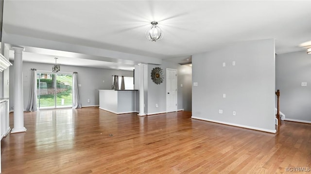 566 Abbey Village Cir, Midlothian, VA 23114 - unfurnished living room featuring decorative columns and light wood-style flooring