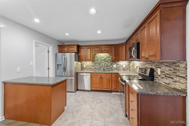 12628 Copperas Ln, Richmond, VA 23233 - kitchen featuring appliances with stainless steel finishes, dark stone counters, backsplash, brown cabinets, and recessed lighting