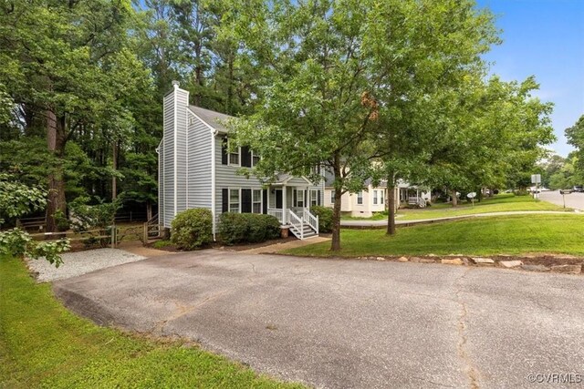 12628 Copperas Ln, Richmond, VA 23233 - view of front of home featuring a chimney, a front yard, and asphalt driveway