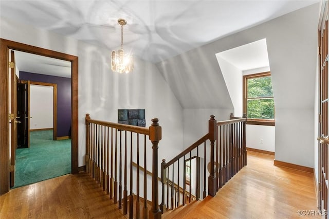 124 Gammons Vw, Bumpass, VA 23024 - corridor featuring an upstairs landing, a chandelier, wood finished floors, and vaulted ceiling