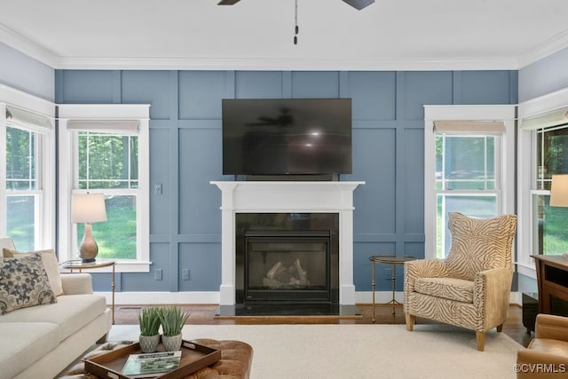 2432 Gammons Creek Dr, Maidens, VA 23102 - living room with a decorative wall, crown molding, a ceiling fan, a glass covered fireplace, and wood finished floors