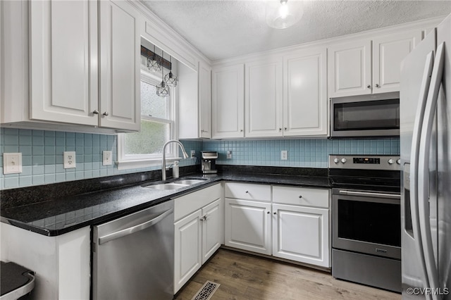2708 Pineridge Ln, Powhatan, VA 23139 - kitchen with stainless steel appliances, white cabinets, decorative backsplash, and a textured ceiling