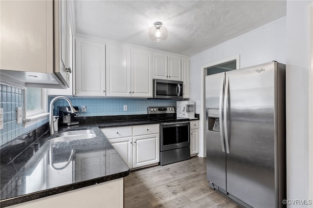 2708 Pineridge Ln, Powhatan, VA 23139 - kitchen featuring stainless steel appliances, white cabinets, backsplash, light wood finished floors, and a textured ceiling