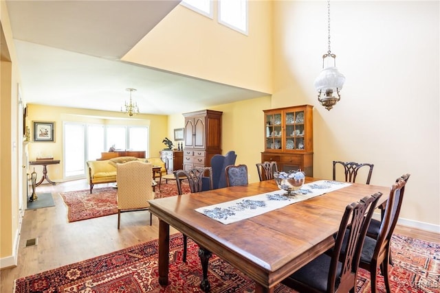 10966 Bland Ridge Dr, South Prince George, VA 23805 - dining area with a chandelier, light wood-type flooring, and a towering ceiling