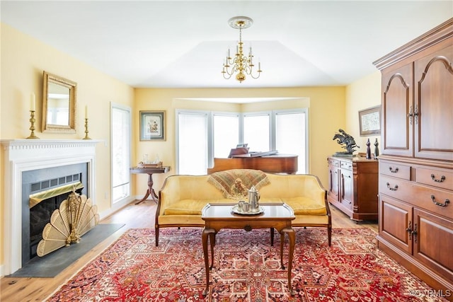 10966 Bland Ridge Dr, South Prince George, VA 23805 - sitting room with light wood-style floors, a chandelier, and a fireplace with raised hearth