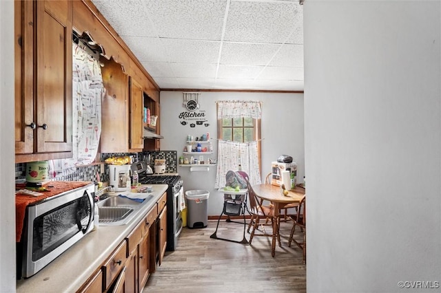 713 Lakeview Ave, Colonial Heights, VA 23834 - kitchen with appliances with stainless steel finishes, brown cabinetry, under cabinet range hood, light wood-type flooring, and a drop ceiling