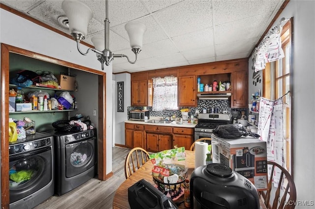 713 Lakeview Ave, Colonial Heights, VA 23834 - kitchen featuring appliances with stainless steel finishes, washing machine and dryer, under cabinet range hood, brown cabinets, and light countertops