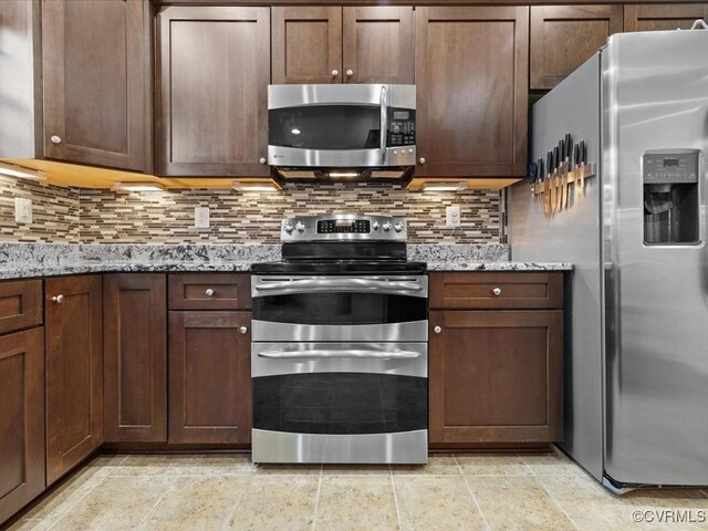 17318 Library Blvd, Ruther Glen, VA 22546 - kitchen featuring appliances with stainless steel finishes, decorative backsplash, light stone countertops, and dark brown cabinets
