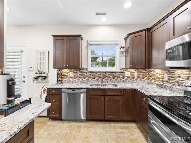 17318 Library Blvd, Ruther Glen, VA 22546 - kitchen featuring appliances with stainless steel finishes, decorative backsplash, light stone counters, dark brown cabinetry, and recessed lighting