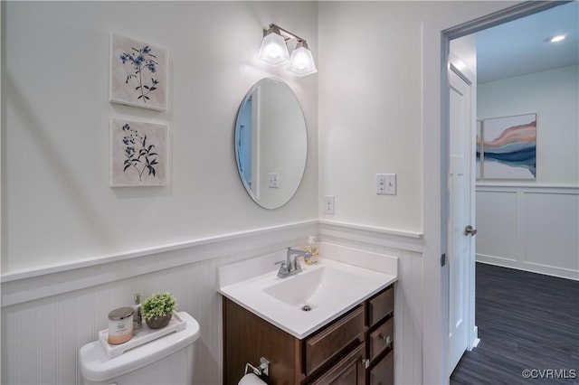 6448 Twin Falls Ter, Moseley, VA 23120 - half bath featuring a decorative wall, vanity, a wainscoted wall, and wood finished floors