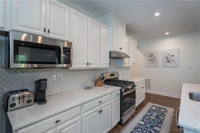 6448 Twin Falls Ter, Moseley, VA 23120 - kitchen with appliances with stainless steel finishes, under cabinet range hood, white cabinetry, tasteful backsplash, and recessed lighting