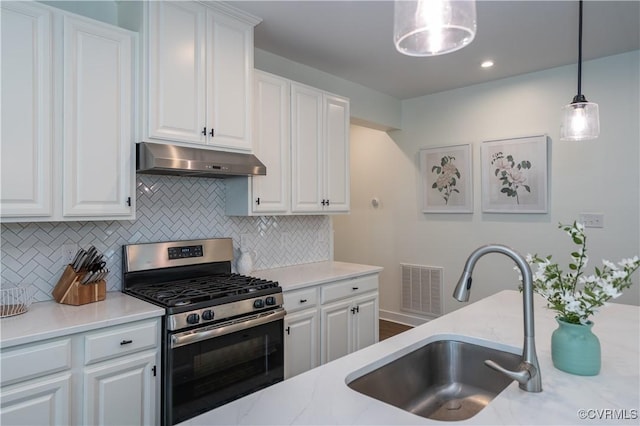 6448 Twin Falls Ter, Moseley, VA 23120 - kitchen with stainless steel range with gas cooktop, under cabinet range hood, backsplash, hanging light fixtures, and white cabinets