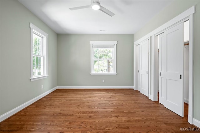 4705 Fitzhugh Ave, Richmond, VA 23230 - unfurnished bedroom featuring two closets, wood finished floors, and a ceiling fan