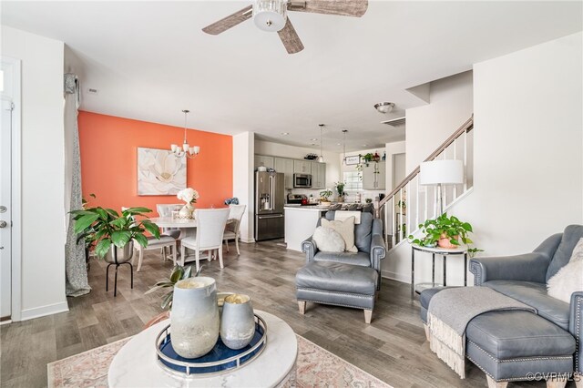 7828 Vermeil St, North Chesterfield, VA 23237 - living room featuring ceiling fan, stairway, wood finished floors, and a chandelier