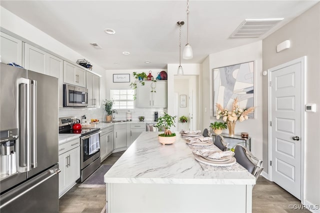 7828 Vermeil St, North Chesterfield, VA 23237 - kitchen with stainless steel appliances, a center island, tasteful backsplash, wood finished floors, and hanging light fixtures
