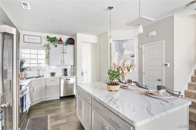 7828 Vermeil St, North Chesterfield, VA 23237 - kitchen featuring appliances with stainless steel finishes, dark wood-style flooring, white cabinetry, decorative light fixtures, and decorative backsplash