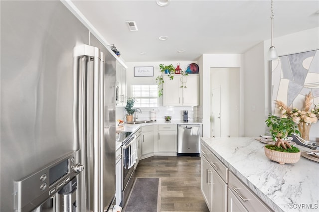 7828 Vermeil St, North Chesterfield, VA 23237 - kitchen featuring appliances with stainless steel finishes, dark wood-style flooring, white cabinets, light stone counters, and decorative light fixtures