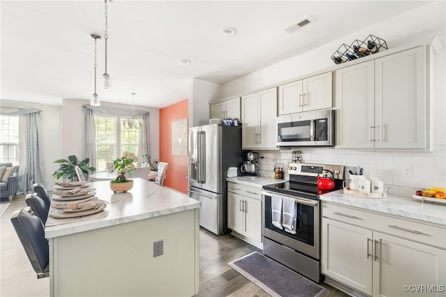 7828 Vermeil St, North Chesterfield, VA 23237 - kitchen featuring appliances with stainless steel finishes, a center island, tasteful backsplash, and wood finished floors