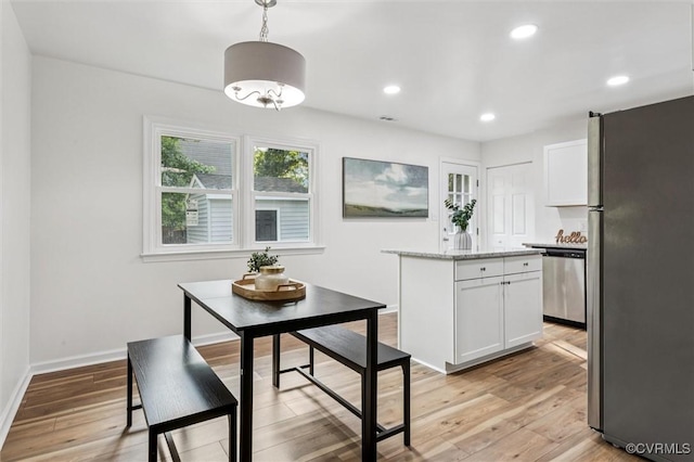 5720 Centerville Rd, Williamsburg, VA 23188 - kitchen with appliances with stainless steel finishes, white cabinets, a kitchen island, light wood-type flooring, and light stone countertops