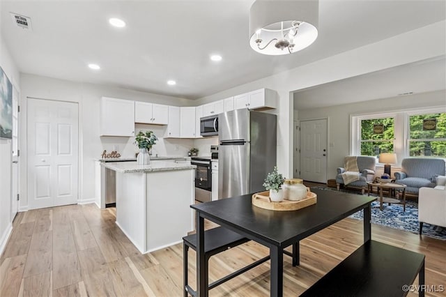5720 Centerville Rd, Williamsburg, VA 23188 - kitchen with stainless steel appliances, a kitchen island, light wood-style floors, white cabinets, and recessed lighting