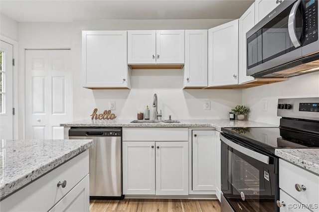 5720 Centerville Rd, Williamsburg, VA 23188 - kitchen with stainless steel appliances, white cabinetry, light stone counters, and light wood finished floors
