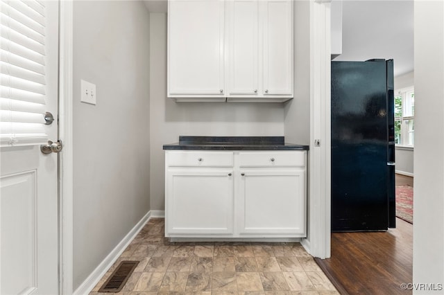 7707 Northern Dancer Ct, Midlothian, VA 23112 - kitchen featuring freestanding refrigerator, dark countertops, and white cabinetry